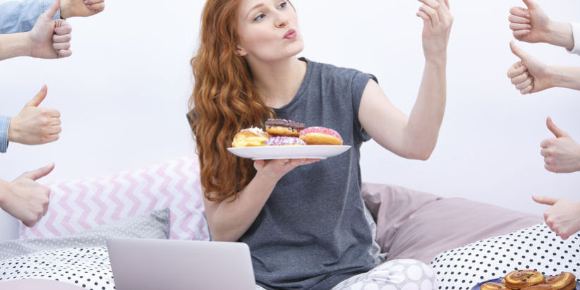 78793960 – pretty woman in bed doing photo with donuts on social media